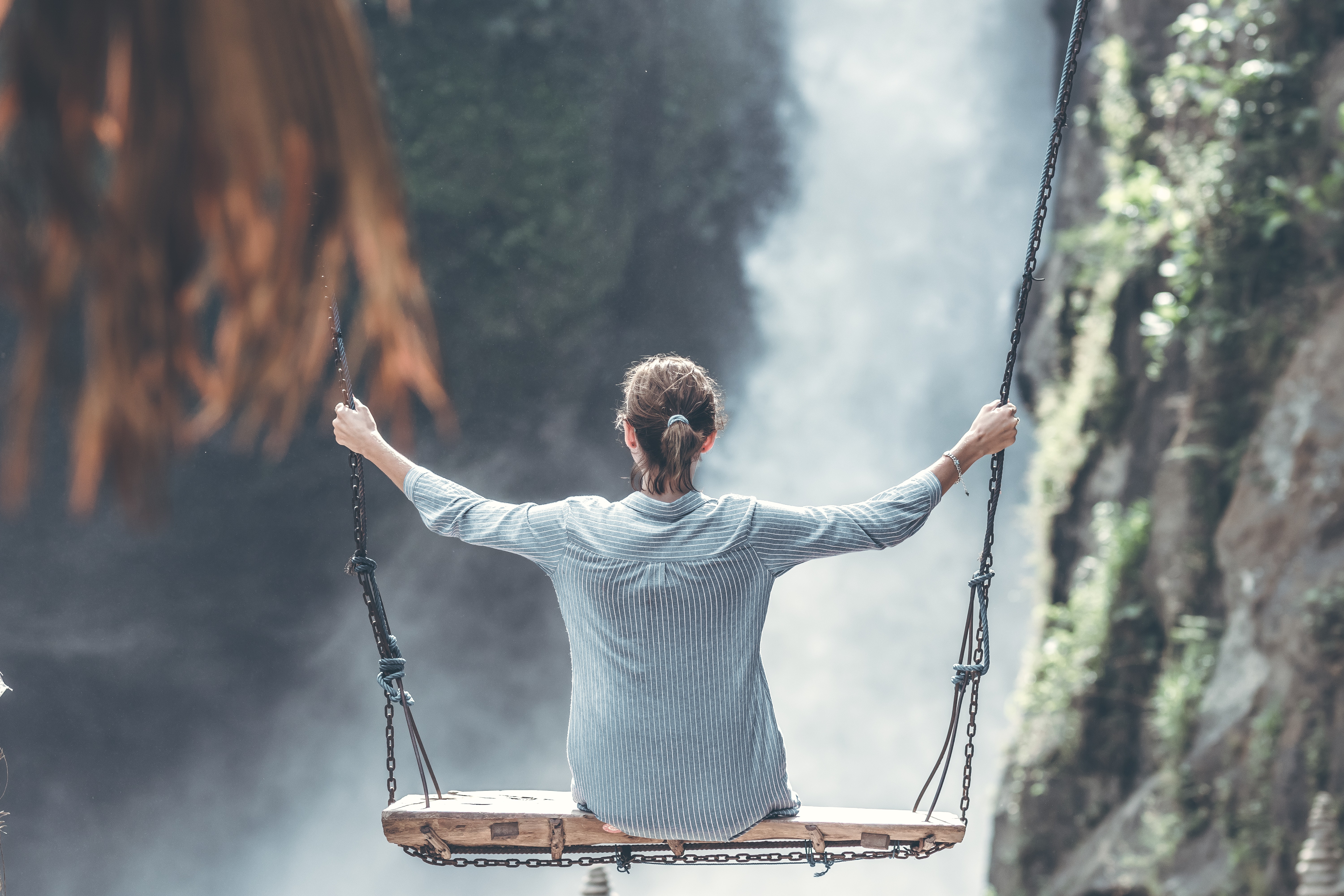 girl swinging in between mountains
