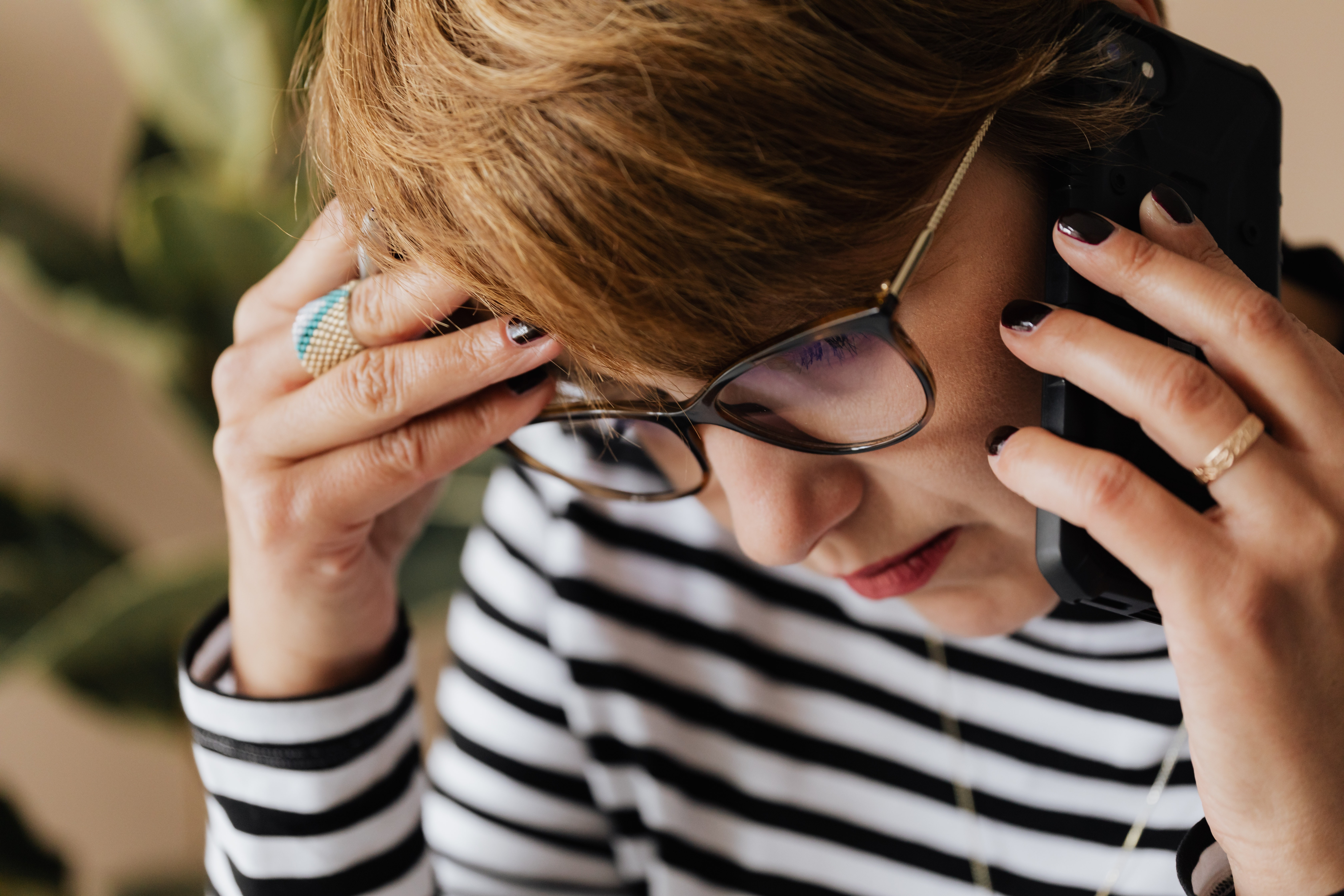 Girl looking down hand on head on the phone