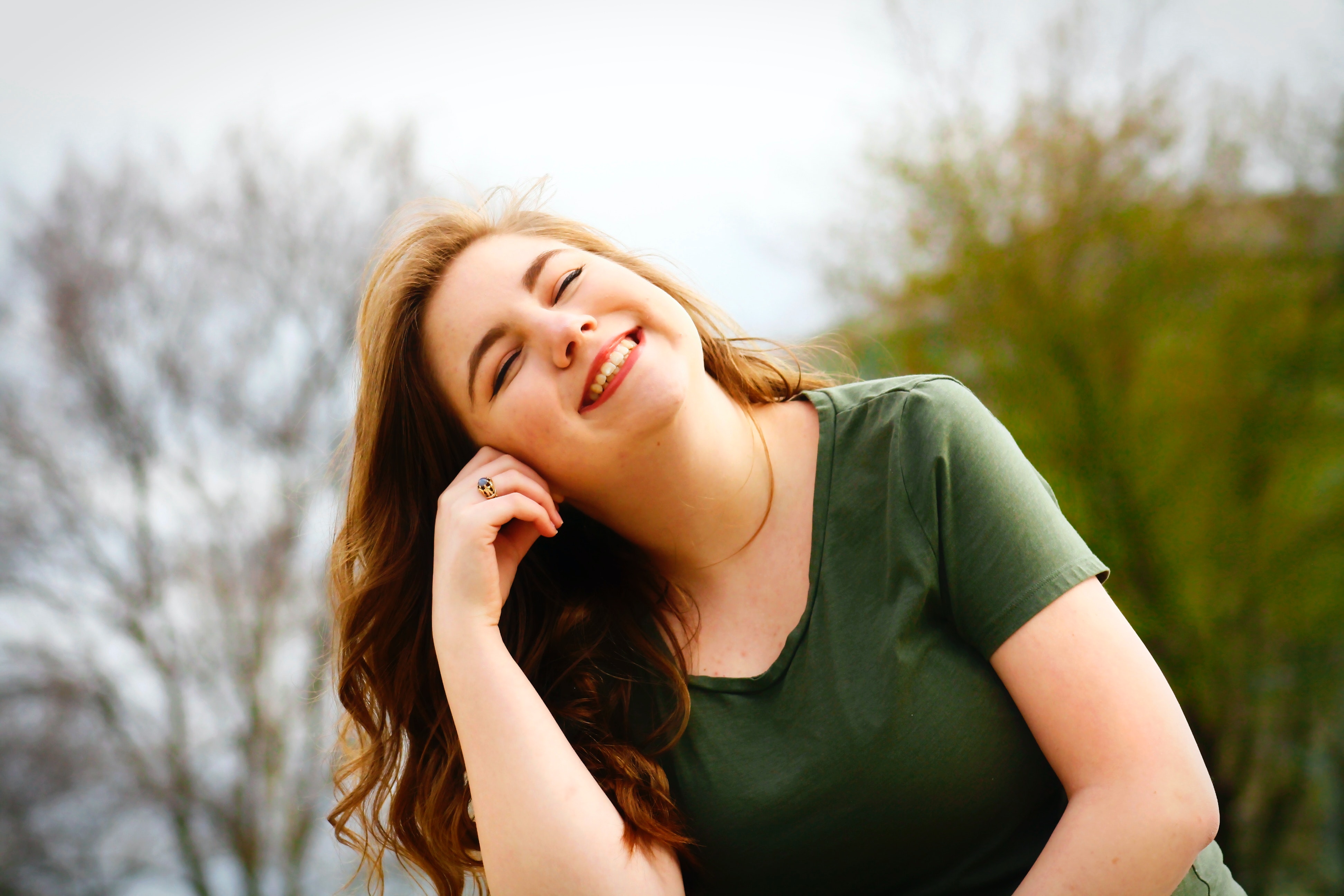 girl with hand on cheek smiling